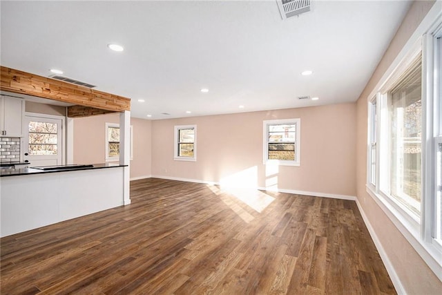 unfurnished living room with dark wood-style floors, visible vents, recessed lighting, and baseboards