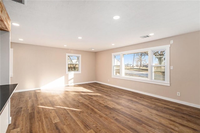 unfurnished living room with visible vents, recessed lighting, baseboards, and wood finished floors