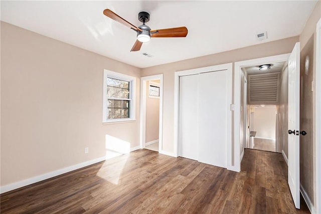 unfurnished bedroom with a ceiling fan, wood finished floors, visible vents, baseboards, and a closet