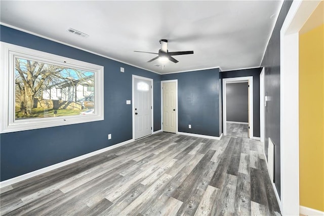 empty room featuring wood-type flooring, ceiling fan, and ornamental molding