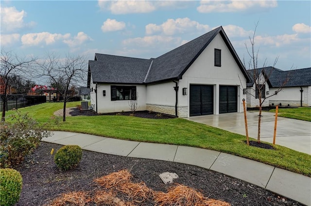 view of front of house with central AC, a front yard, and a garage