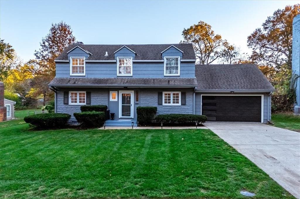 view of front of property featuring a front lawn and a garage