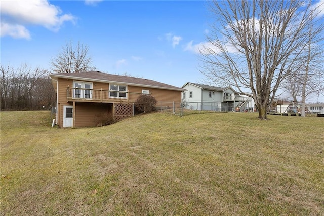 back of property with a lawn and a deck