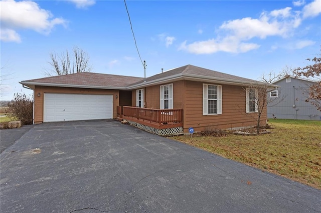 single story home with a garage, a deck, and a front lawn