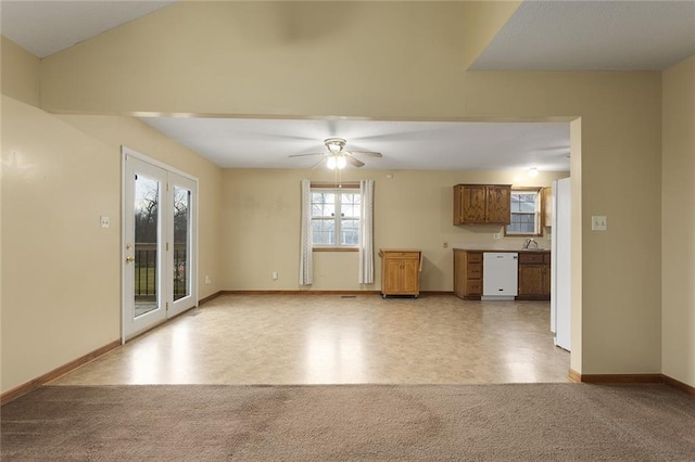 unfurnished living room featuring french doors, light colored carpet, and ceiling fan