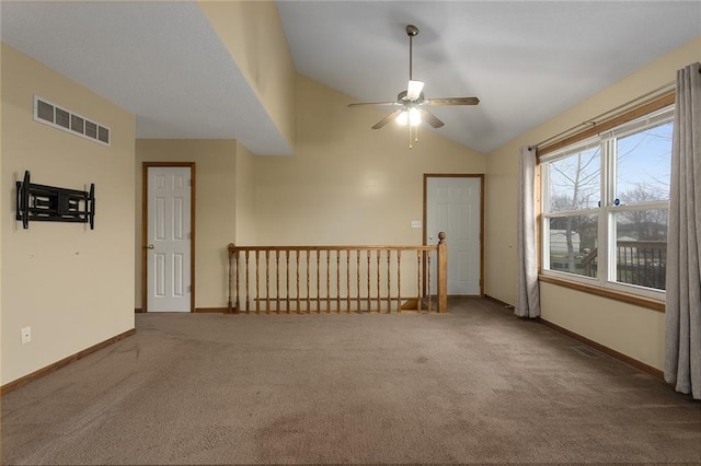 carpeted empty room with vaulted ceiling and ceiling fan