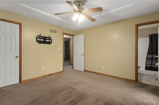 unfurnished bedroom featuring ensuite bath, ceiling fan, and light carpet