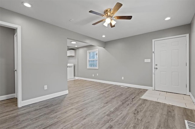 unfurnished living room featuring ceiling fan and light hardwood / wood-style flooring