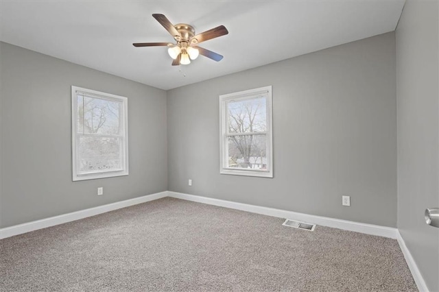 carpeted empty room with ceiling fan and a healthy amount of sunlight