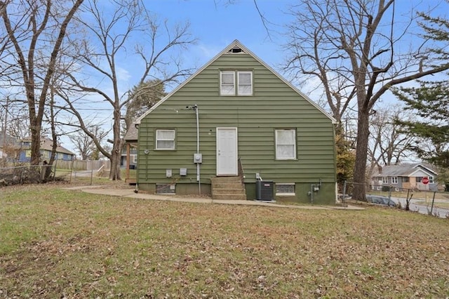 back of property featuring a lawn and central AC