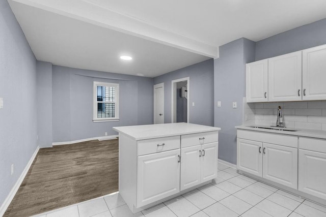 kitchen with white cabinets, decorative backsplash, and sink