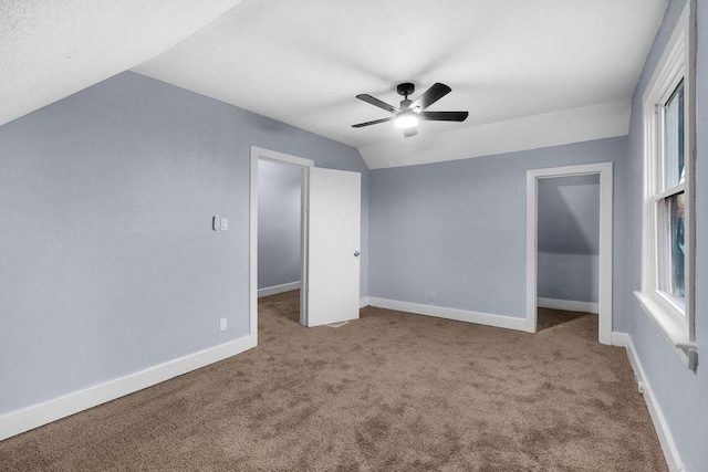 unfurnished bedroom featuring carpet flooring, ceiling fan, a closet, and vaulted ceiling