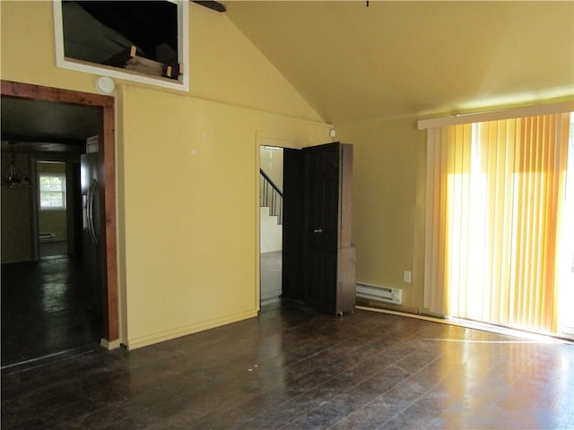 unfurnished room featuring stairway, baseboard heating, wood finished floors, and lofted ceiling