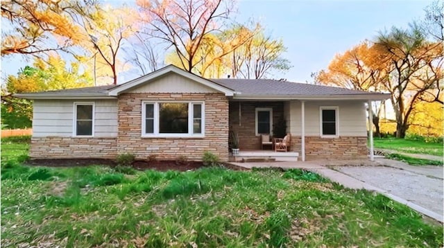 ranch-style house with stone siding, a front lawn, and covered porch