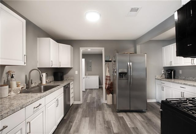 kitchen featuring stainless steel appliances, a sink, visible vents, light wood-style floors, and white cabinets