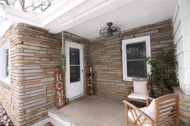 doorway to property featuring stone siding and covered porch