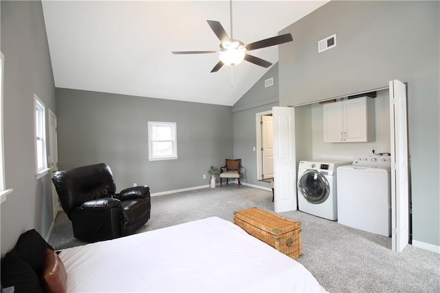 bedroom featuring light colored carpet, visible vents, separate washer and dryer, high vaulted ceiling, and baseboards