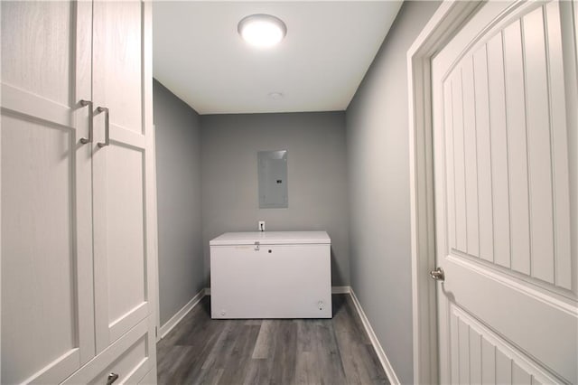 laundry area with laundry area, baseboards, electric panel, and dark wood-style floors