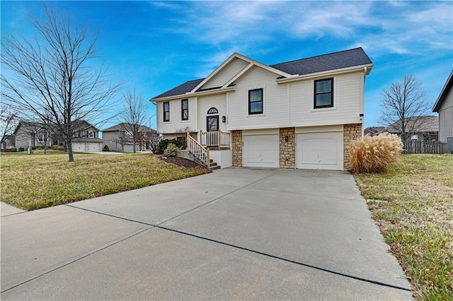 raised ranch with a garage and a front lawn