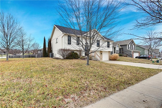 view of front facade featuring a garage, a front yard, and central AC