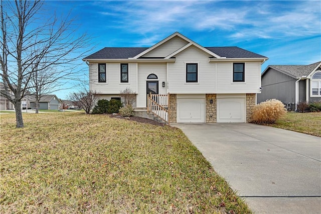 raised ranch with a front lawn and a garage