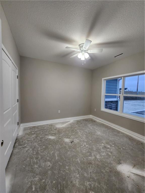 unfurnished bedroom featuring a water view, ceiling fan, concrete floors, and a textured ceiling