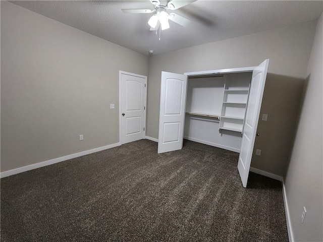 unfurnished bedroom with a closet, dark carpet, ceiling fan, a textured ceiling, and baseboards