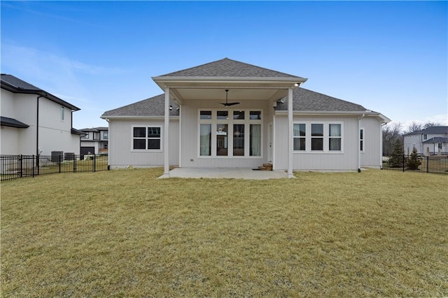 rear view of house with a patio, a fenced backyard, a yard, roof with shingles, and ceiling fan