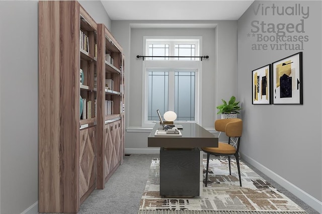 office area featuring baseboards and light colored carpet