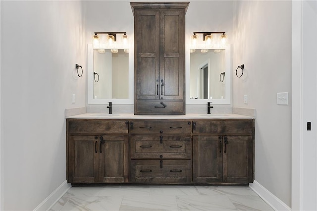 bathroom featuring double vanity, marble finish floor, and a sink