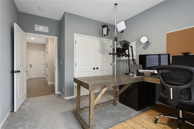 office area featuring visible vents, baseboards, and carpet flooring