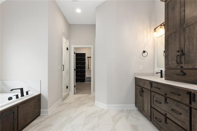 full bathroom with a walk in closet, baseboards, vanity, and marble finish floor