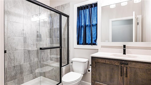 full bathroom with toilet, vanity, and a stall shower
