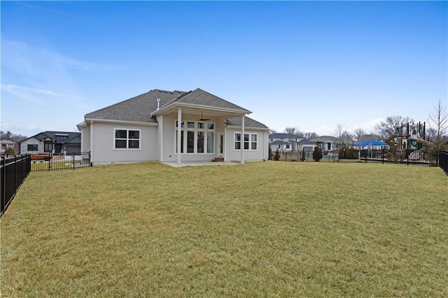 rear view of property with a fenced backyard and a yard