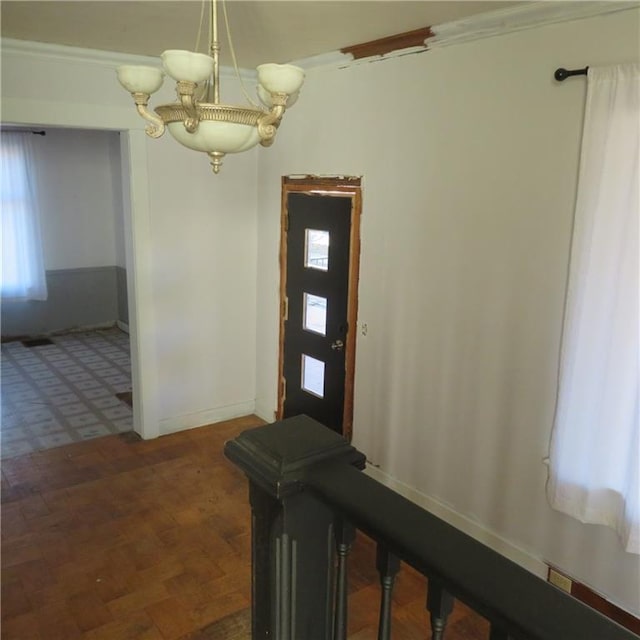 entryway with baseboards, a wealth of natural light, and an inviting chandelier