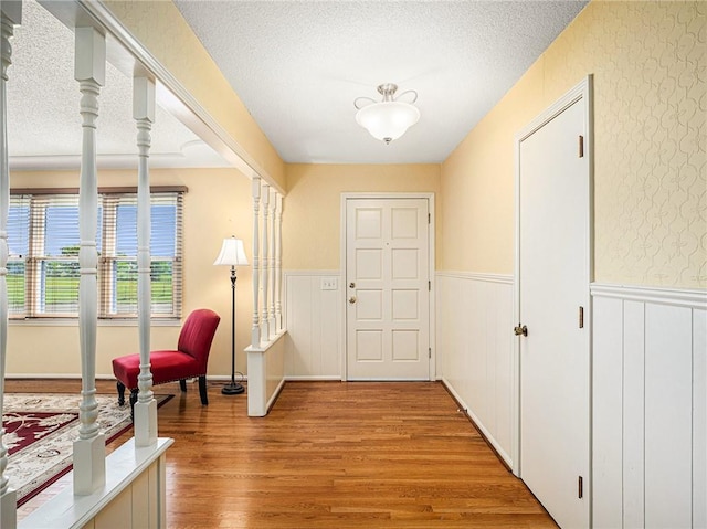 doorway to outside featuring light hardwood / wood-style floors and a textured ceiling