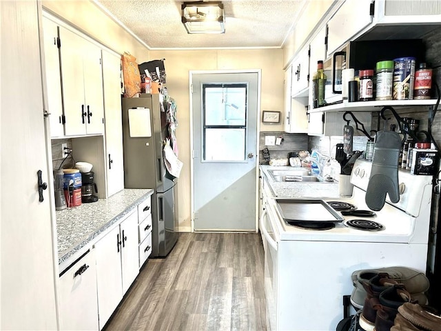 kitchen with a textured ceiling, electric range, and white cabinetry