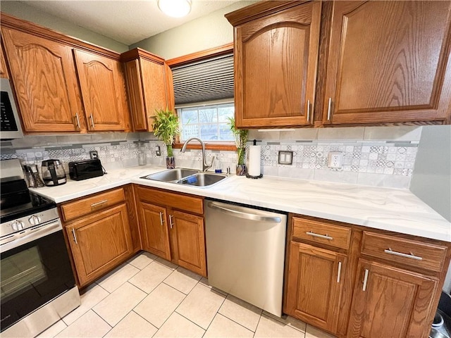 kitchen with light tile patterned flooring, stainless steel appliances, tasteful backsplash, and sink