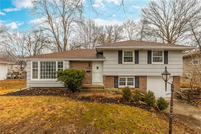 tri-level home featuring a garage and a front yard