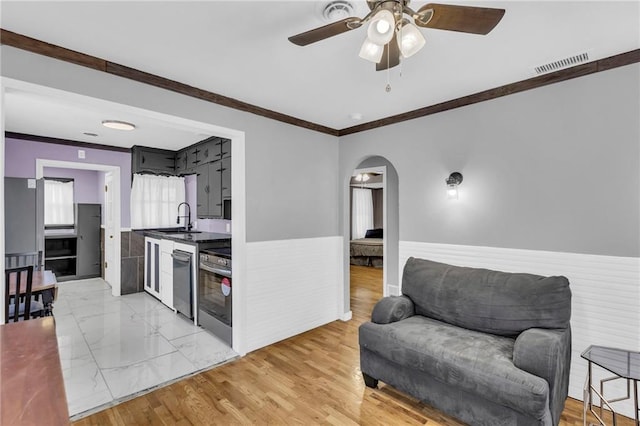 kitchen with dishwasher, stove, sink, crown molding, and ceiling fan