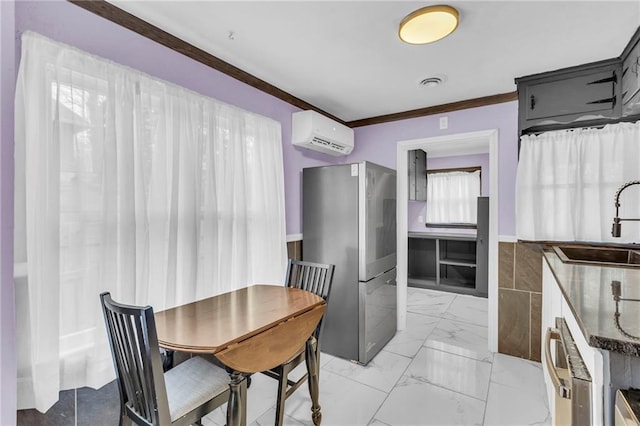 kitchen featuring a wall mounted air conditioner, crown molding, sink, and stainless steel refrigerator