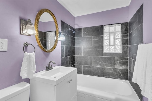 full bathroom featuring vanity, tiled shower / bath combo, and toilet