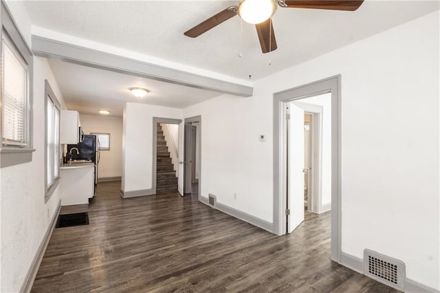 unfurnished living room with dark hardwood / wood-style floors, ceiling fan, and sink