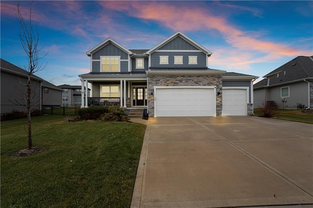 craftsman inspired home featuring a lawn, a porch, and a garage