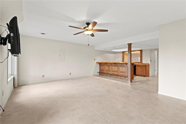 unfurnished living room featuring ceiling fan and indoor bar