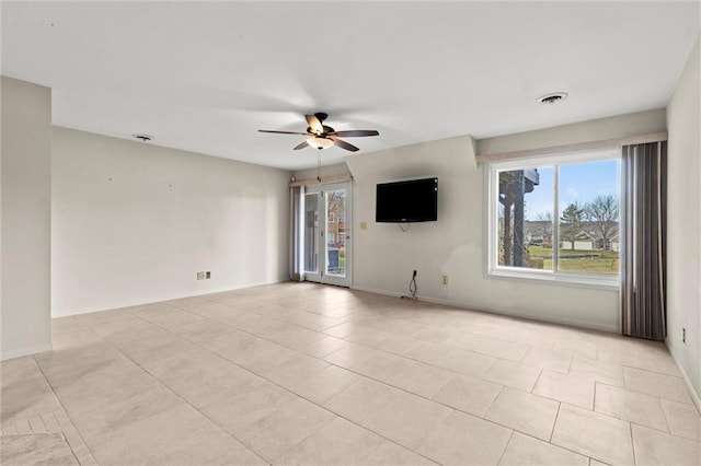 empty room featuring ceiling fan, light tile patterned floors, and a wealth of natural light