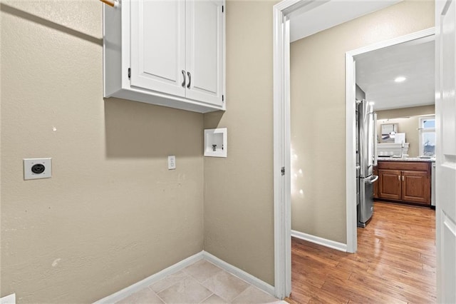 laundry area with cabinets, hookup for a washing machine, light hardwood / wood-style flooring, and electric dryer hookup