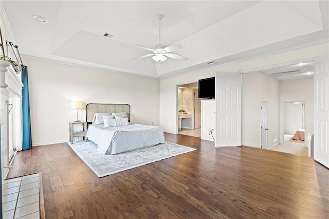 bedroom with dark hardwood / wood-style flooring, a tray ceiling, and ceiling fan