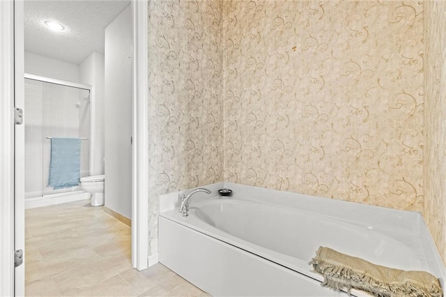 bathroom featuring toilet, tile patterned flooring, a textured ceiling, and shower with separate bathtub