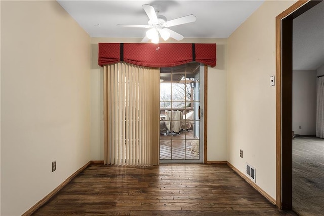 spare room featuring dark wood-type flooring and ceiling fan